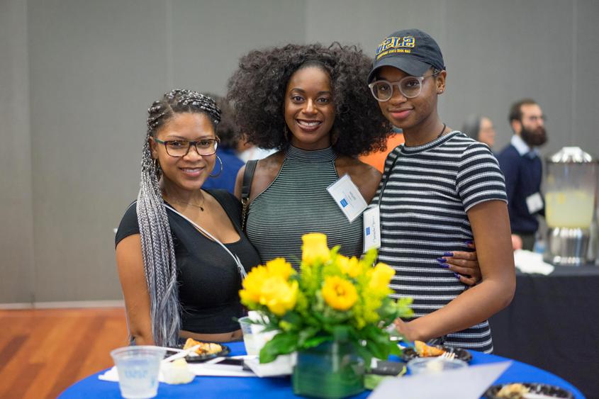 Students who received scholarships gather together around a table.